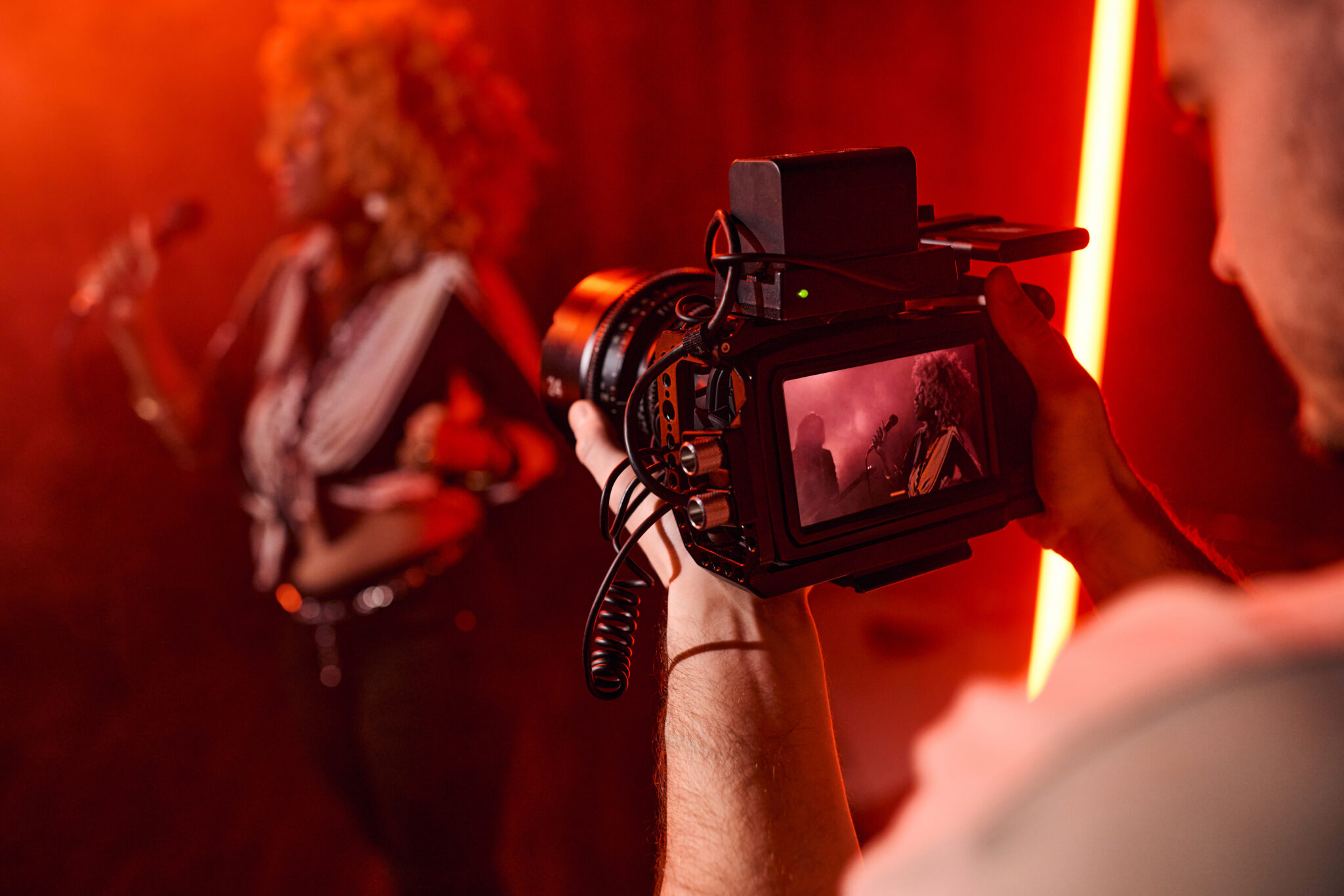 Close up of unrecognizable videographer holding camera and filming music video for jazz band copy space